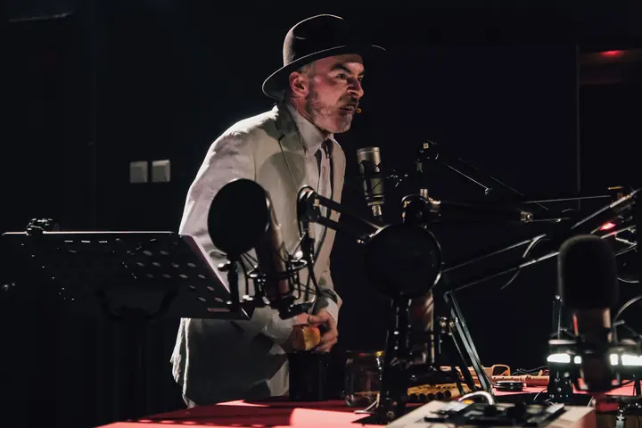 Konstanty pochylony nad mikrofonami
